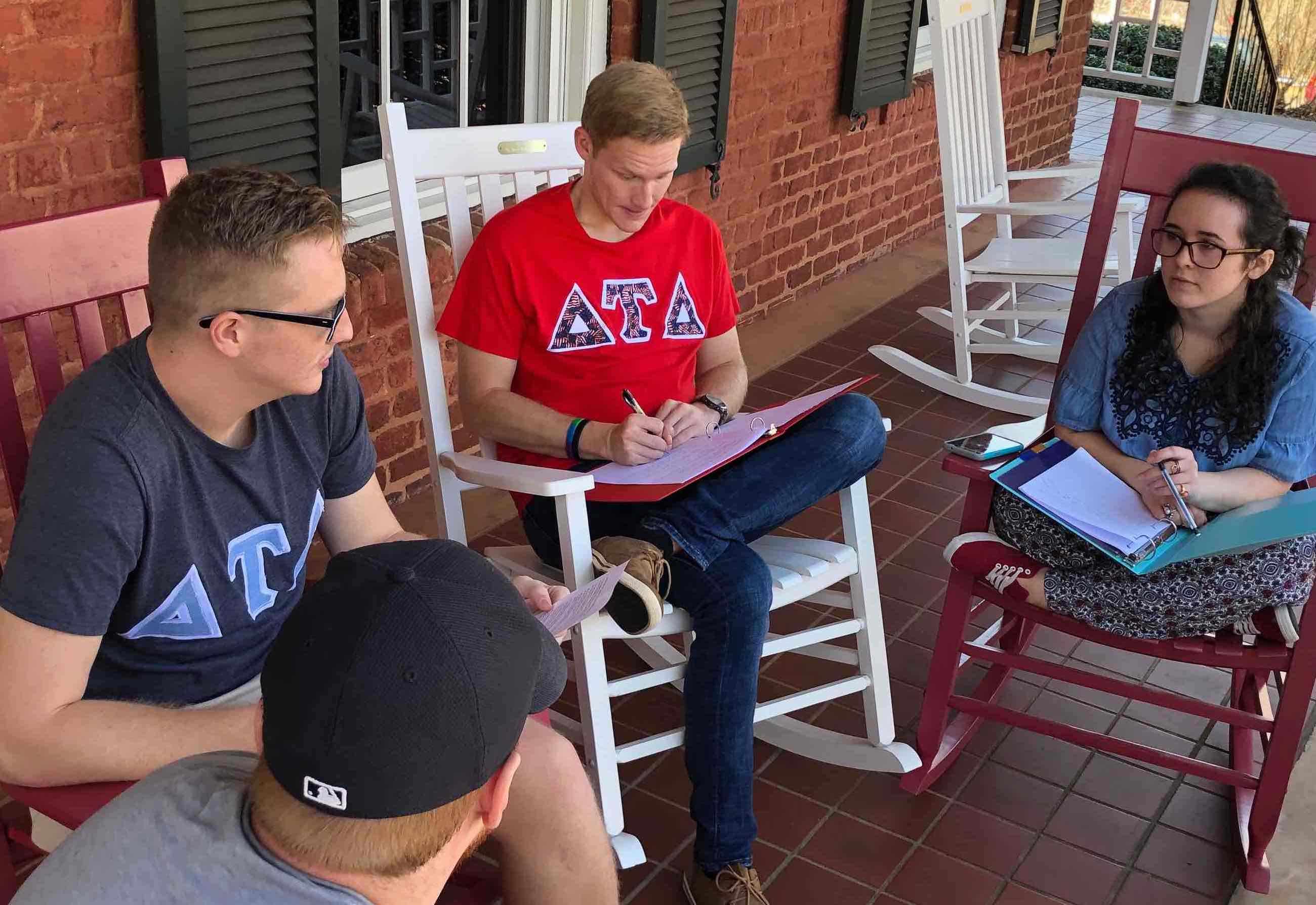 Three young men study outside