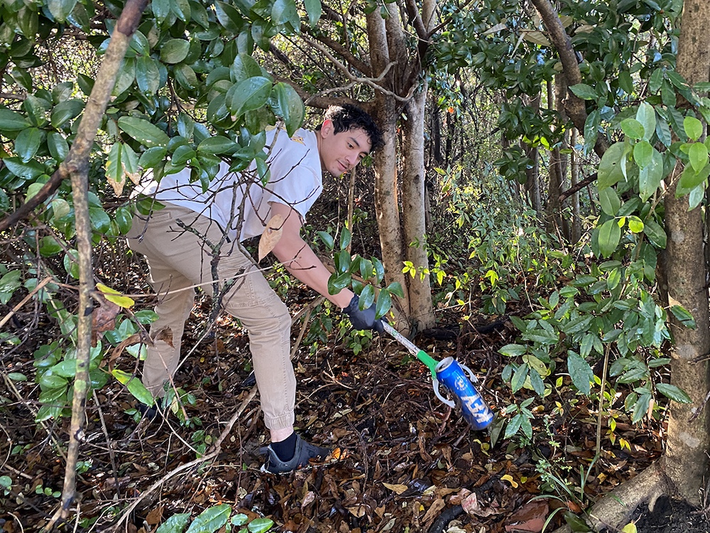 Student participating in community clean-up